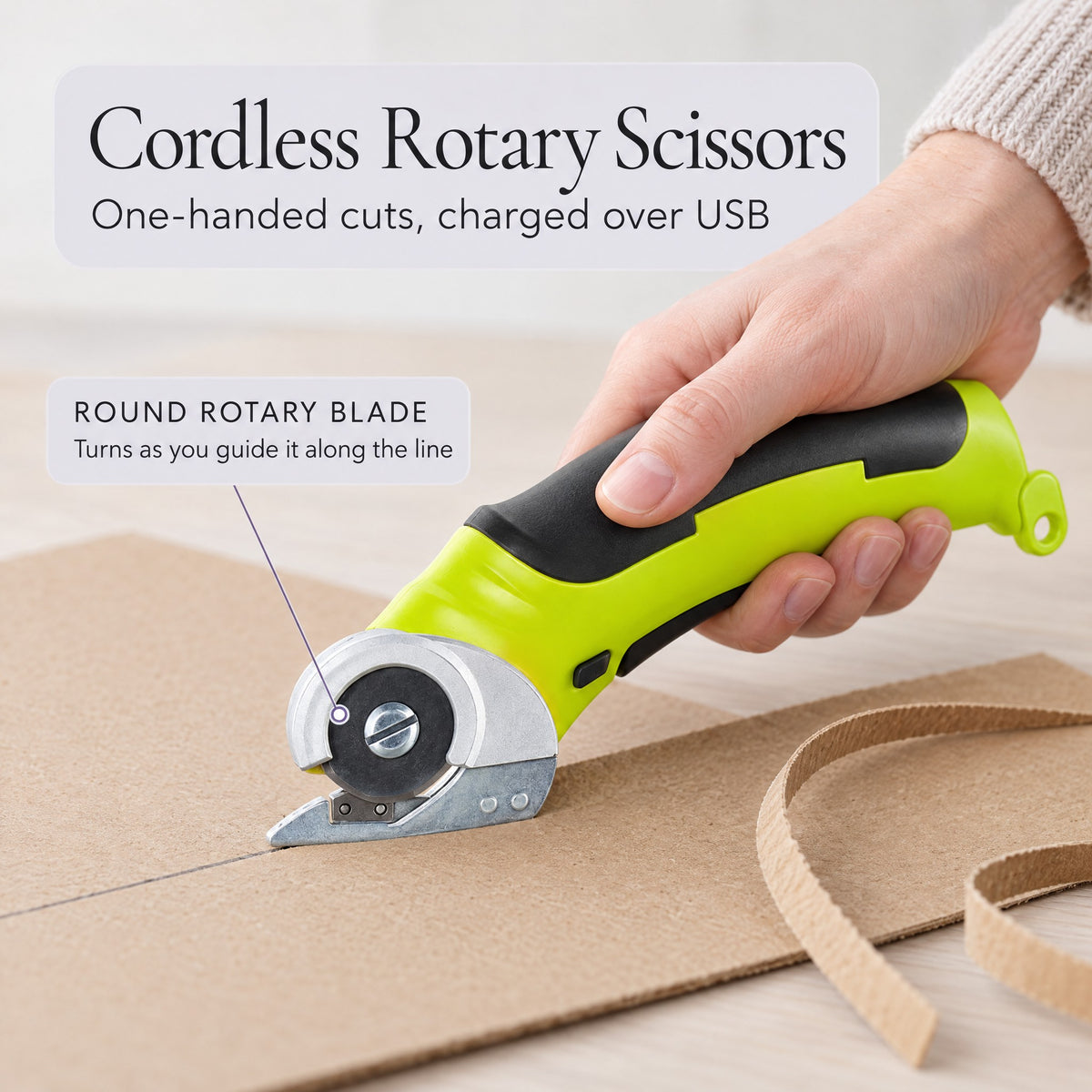 Cordless rotary scissors cutting along a pencil line on kraft cardboard
