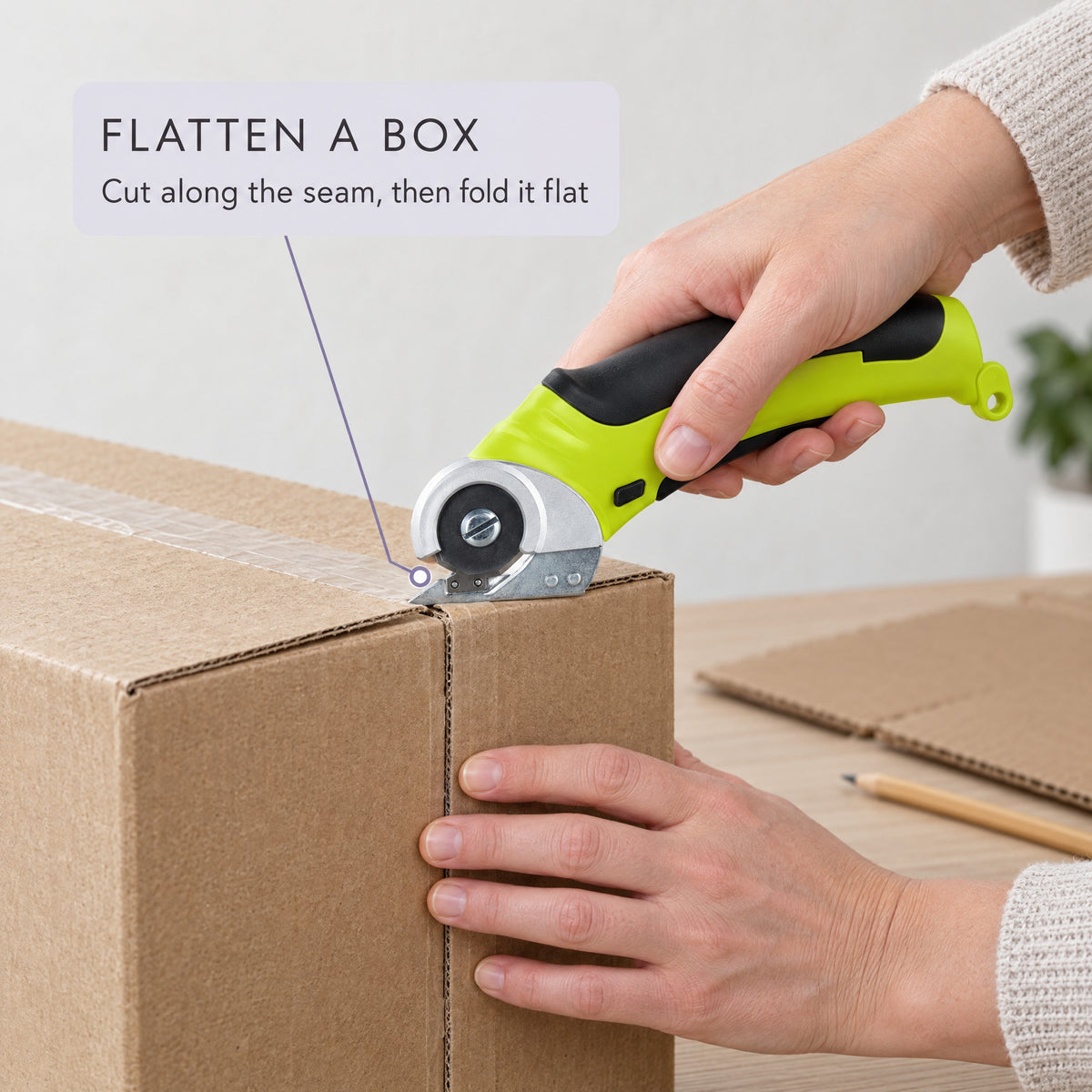 Cutting down the seam of a cardboard box with the cordless rotary scissors